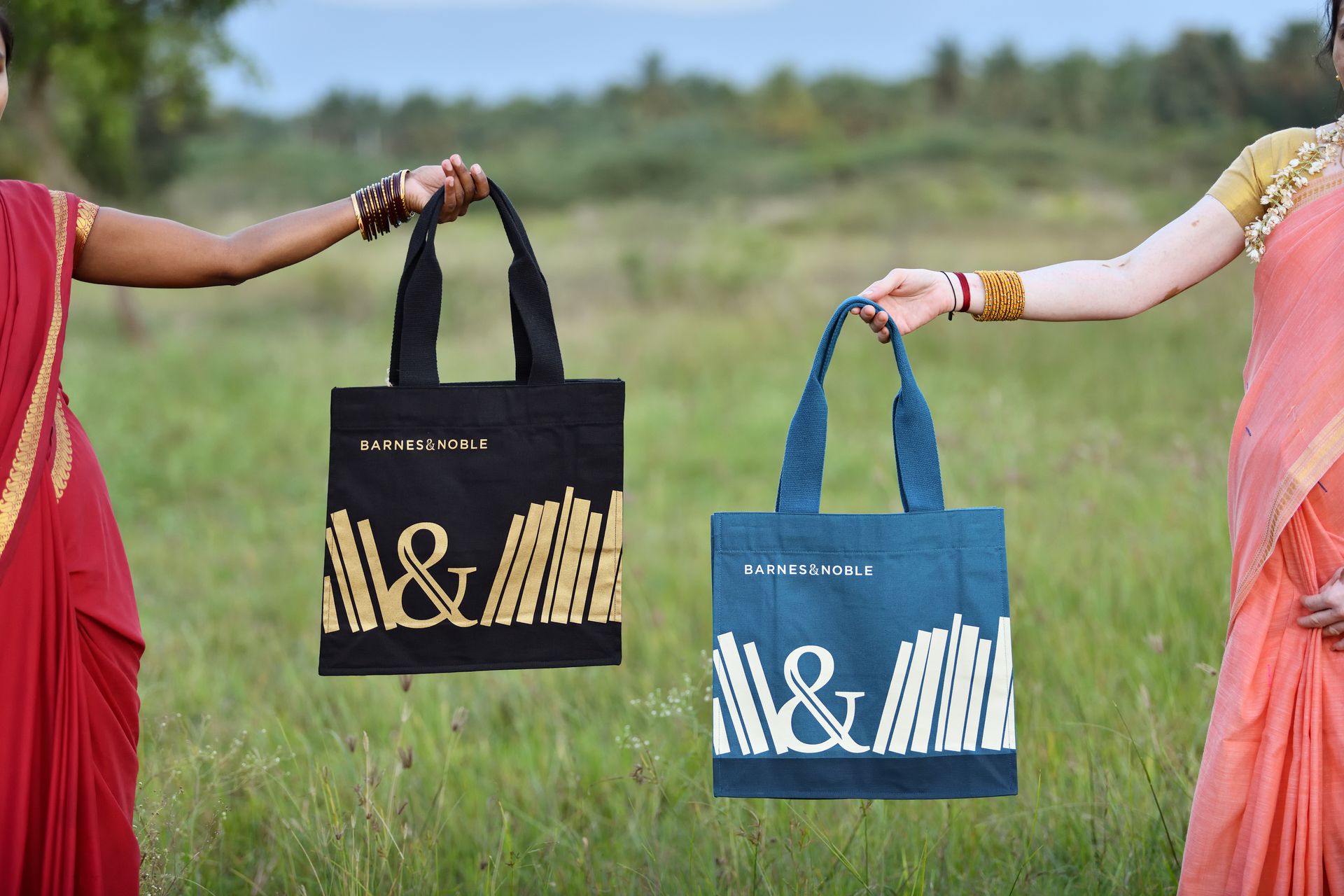Women holding Barnes & Noble bag in a field