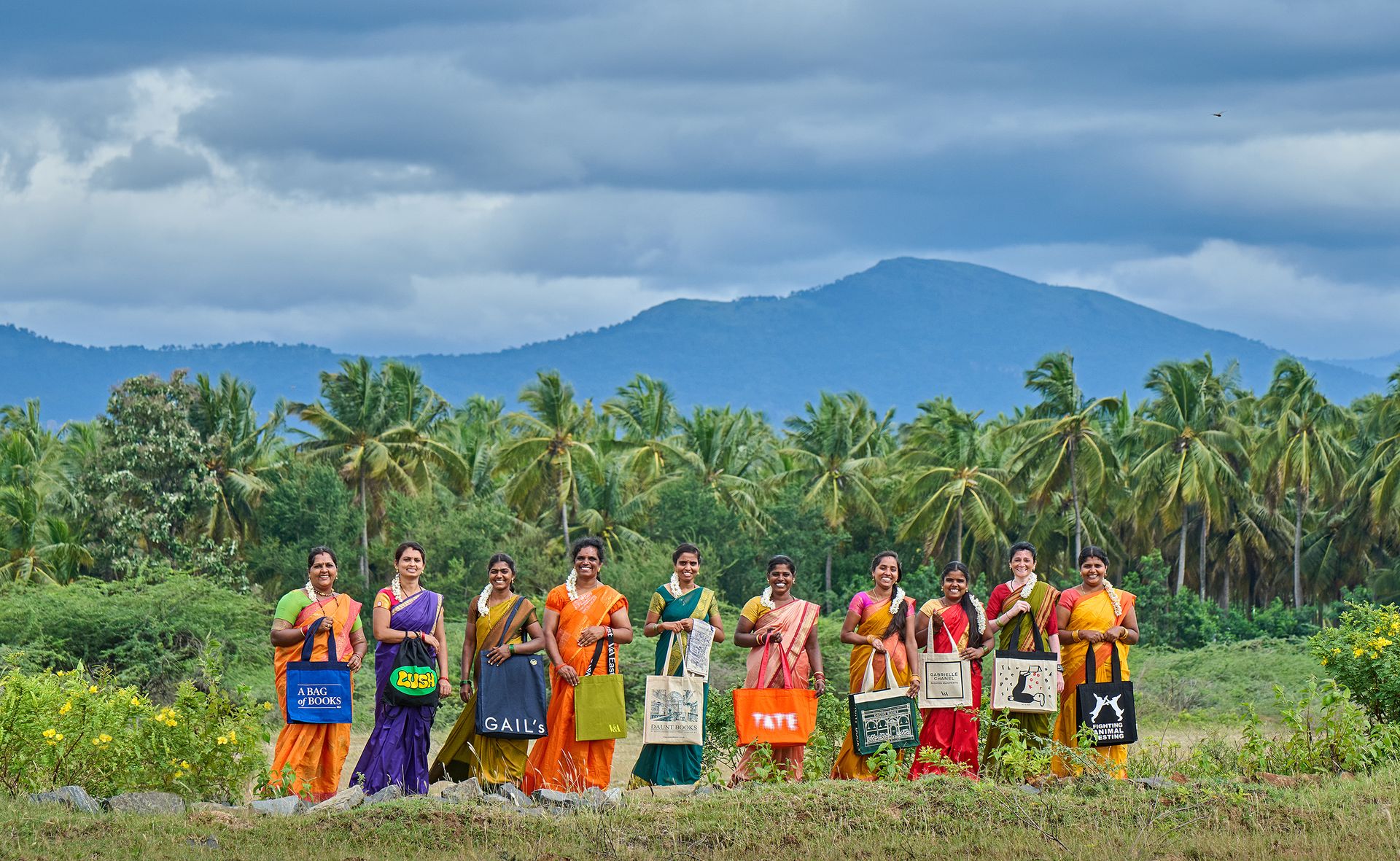Women holding bags in field