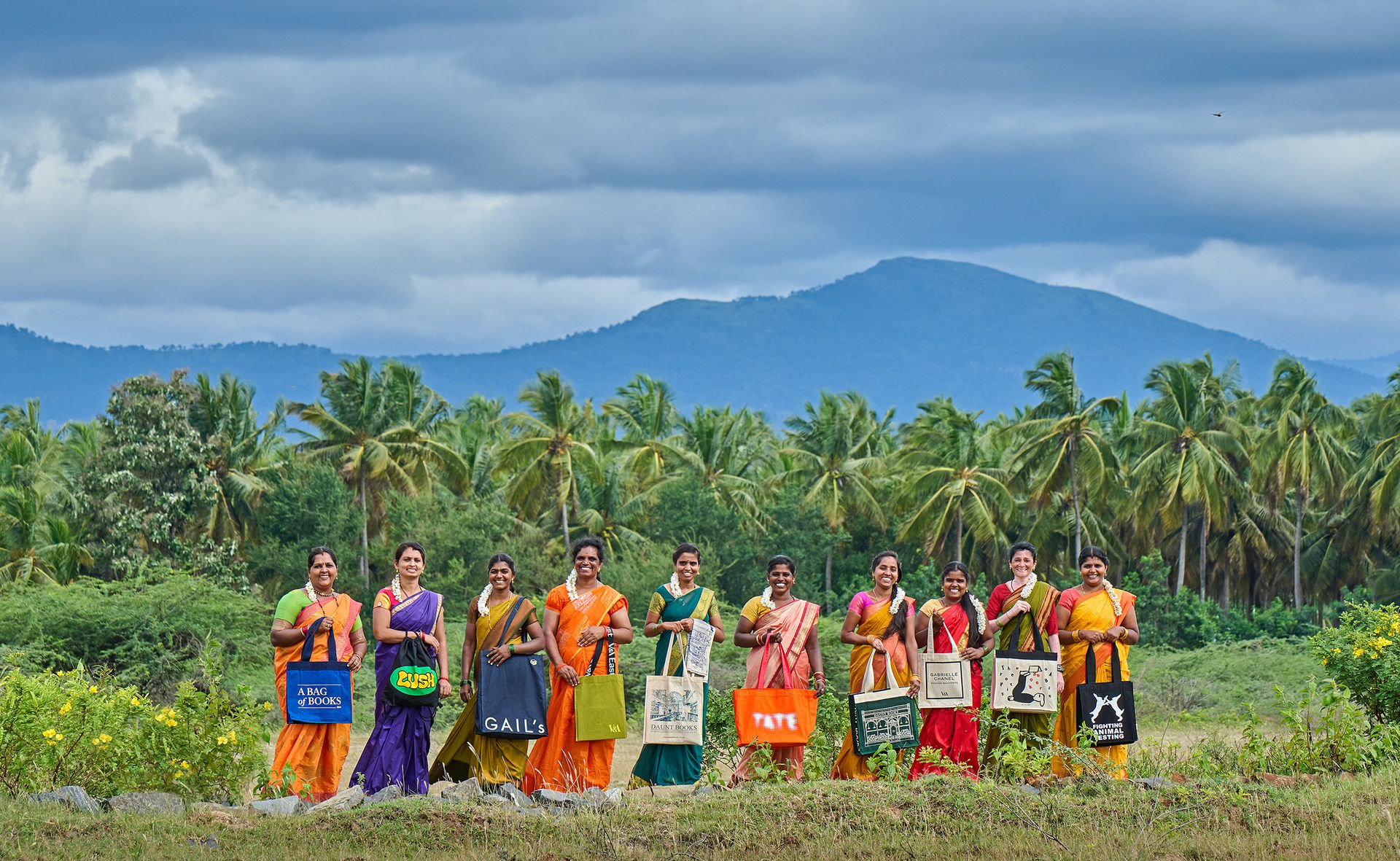 Women holding bags in field