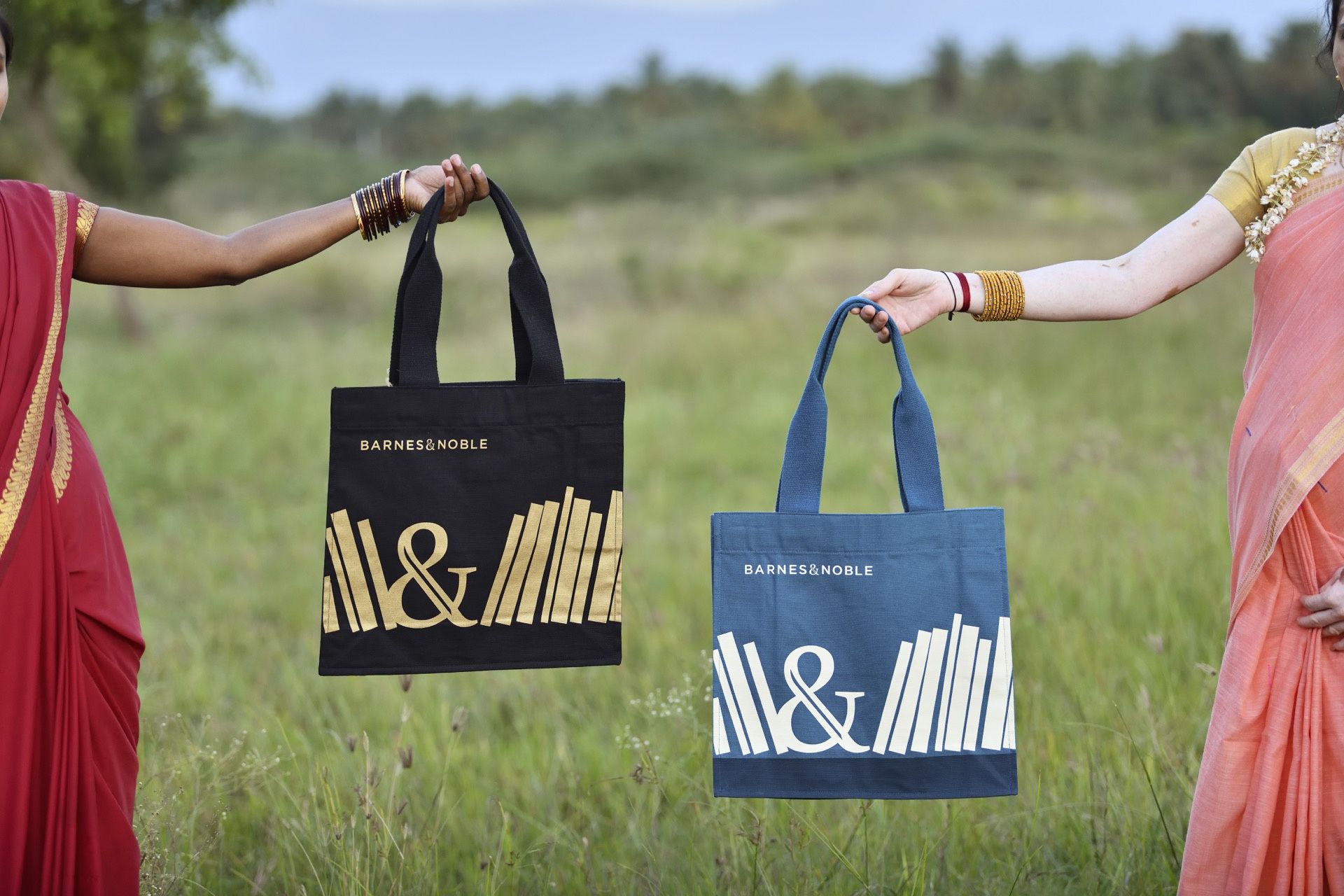 Women holding Barnes & Noble bag in a field